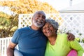 Smiling african american senior couple holding yoga mats in garden and looking at camera Royalty Free Stock Photo