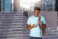 Smiling african american student looking at cellphone Royalty Free Stock Photo