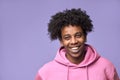 Smiling African American teen guy wearing pink hoodie isolated on purple. Royalty Free Stock Photo