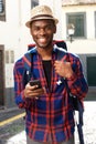 Smiling african american travel man with backpack and mobile phone Royalty Free Stock Photo