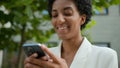 Smiling African American woman business chatting in social media mobile app texting network waiting taxi order looking Royalty Free Stock Photo