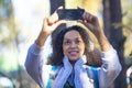 Smiling African American woman in the forest taking a selfie on a smartphone. Royalty Free Stock Photo