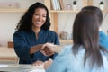 Smiling African American woman handshake couple clients