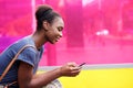 Smiling african american woman looking at mobile phone Royalty Free Stock Photo
