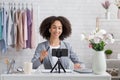 Smiling african american woman looking at webcam in living room and streaming video