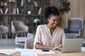 Smiling African American woman manage finances on laptop