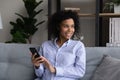 Smiling African American woman use cellphone dreaming Royalty Free Stock Photo