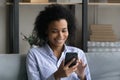 Smiling African American woman use smartphone at home Royalty Free Stock Photo