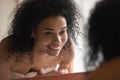 Smiling african American woman wash face in clear water