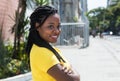 Smiling african american woman in yellow shirt looking sideways Royalty Free Stock Photo