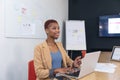 Smiling african american young businesswoman working on laptop in board room Royalty Free Stock Photo