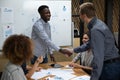 Smiling african american young leader shaking hands with caucasian colleague. Royalty Free Stock Photo
