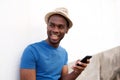 Smiling african american young man holding cellphone