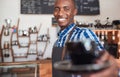 Smiling African barista offering up a fresh cup of cappuccino Royalty Free Stock Photo