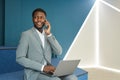 Smiling African Businessman Speaking by Phone in Blue Office Royalty Free Stock Photo