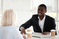 Smiling african businessman in suit speaking to colleague at mee Royalty Free Stock Photo