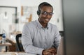 Smiling African businessman talking on a headset and using a laptop Royalty Free Stock Photo