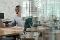 Smiling African businessman using a laptop and talking on a headset Royalty Free Stock Photo