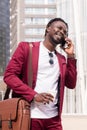 Smiling african businessman walks talking by phone Royalty Free Stock Photo