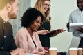 Smiling African businesswoman working with colleagues in an offi