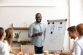 Smiling african conference speaker give flipchart presentation at office seminar Royalty Free Stock Photo