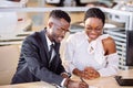 African couple getting car key from dealer in showroom and signing contract Royalty Free Stock Photo