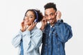 Smiling african couple in denim shirts listning music by headphones Royalty Free Stock Photo