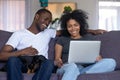 Smiling african couple laughing using computer with dog at home Royalty Free Stock Photo