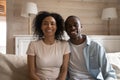 Smiling african couple sitting on couch making video call Royalty Free Stock Photo