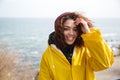 Smiling african curly young lady wearing yellow coat