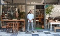 Smiling African entrepreneur standing welcomingly in front of his cafe