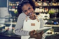 Smiling African entrepreneur talking on the phone in her cafe Royalty Free Stock Photo