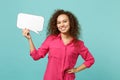 Smiling african girl in casual clothes holding empty blank Say cloud, speech bubble isolated on blue turquoise wall Royalty Free Stock Photo