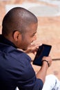 Smiling african man using digital tablet outside Royalty Free Stock Photo