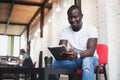 Smiling African man using tablet for video conversation in modern office. Royalty Free Stock Photo