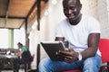 Smiling African man using tablet for video conversation in modern office. Royalty Free Stock Photo