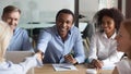 Smiling african manager handshaking greeting caucasian client at group negotiations Royalty Free Stock Photo