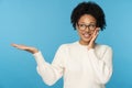 Smiling African woman with curly hair holding copy space on the palm for advertising, offer, product Royalty Free Stock Photo