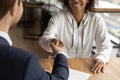 Smiling african woman handshaking get acquainted with young male realtor