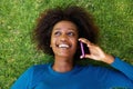 Smiling african woman lying on grass talking on mobile phone Royalty Free Stock Photo