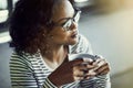 Smiling African woman thinking while drinking coffee in a cafe Royalty Free Stock Photo