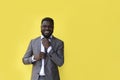 Smiling Afro-American businessman with folded arms against yellow background Royalty Free Stock Photo