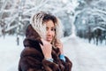 Smiling afro american girl wearing in fur coat in winter park Royalty Free Stock Photo