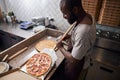 Handsome young man placing pepperoni pizza in paper box Royalty Free Stock Photo