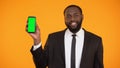 Smiling afro-american man in formalwear showing prekeyed phone, advertisement