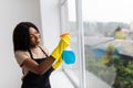 Smiling afro american woman cleaning glass window at home Royalty Free Stock Photo