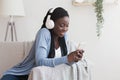 Smiling Afro Girl Wearing Wireless Headphones, Listening Favorite Music On Smartphone Royalty Free Stock Photo