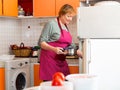 Aged housewife putting pan in fridge Royalty Free Stock Photo