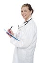 Smiling aged surgeon holding pen and clipboard Royalty Free Stock Photo