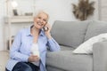 Smiling aged woman having pleasant phone call at home Royalty Free Stock Photo